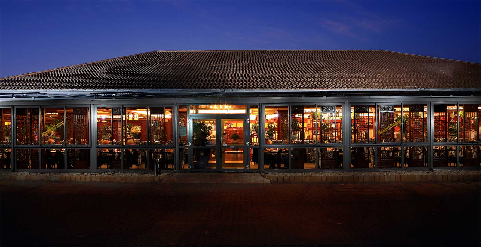 Außenansicht des Dynasty Restaurants in Weinheim mit dem markanten Eingangsbereich und den hauseigenen Parkplätzen direkt vor der Tür