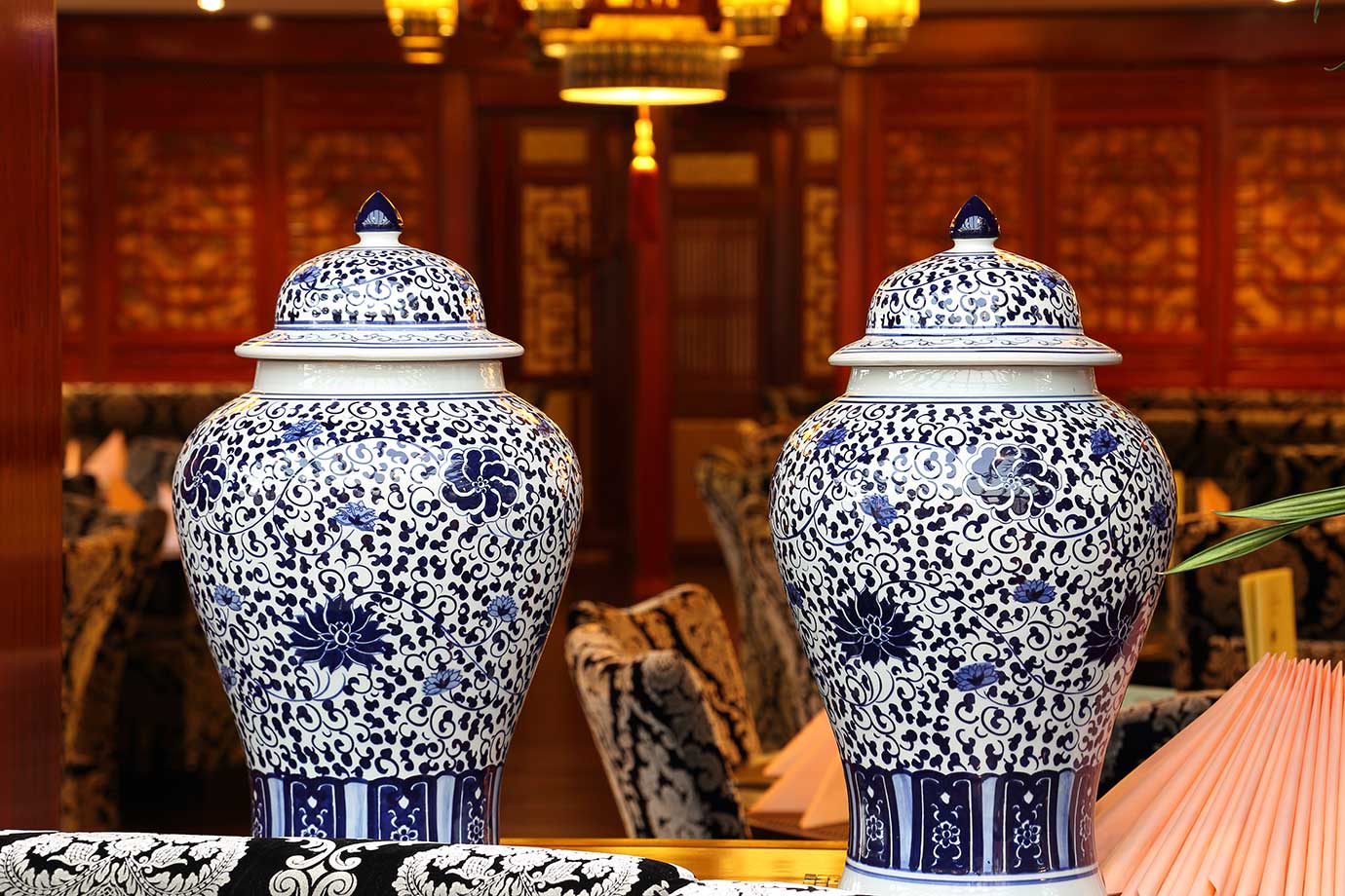 Detailaufnahme der Innendekoration mit großen, traditionell chinesischen Vasen und warmem Lichtdesign